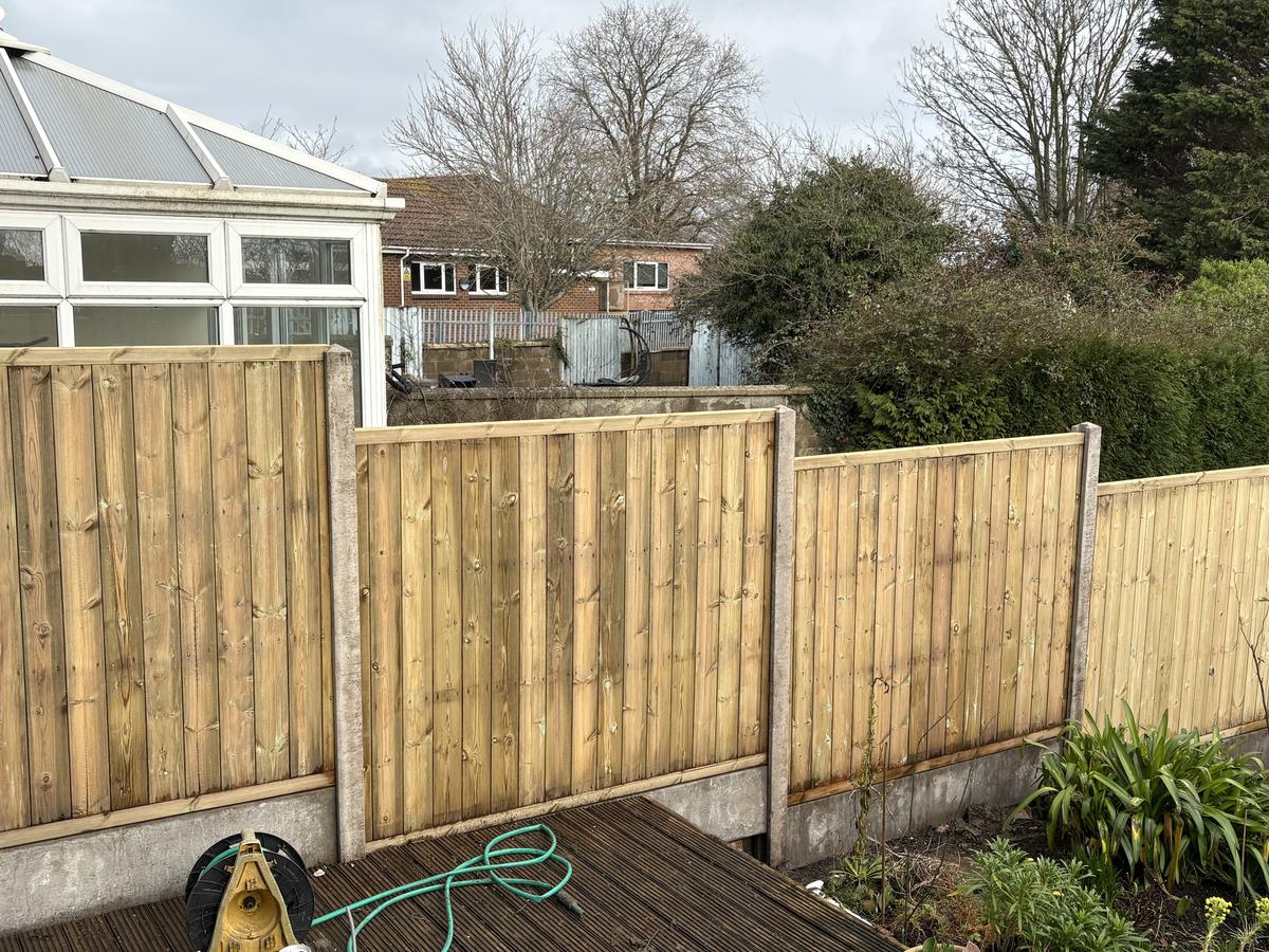 Close-board fence panels set on concrete posts and gravel boards