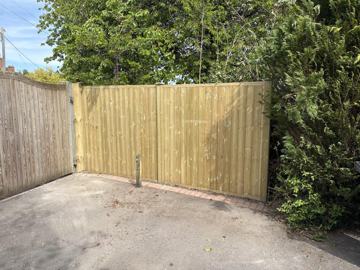 New close-board driveway gates and fencing beside mature trees