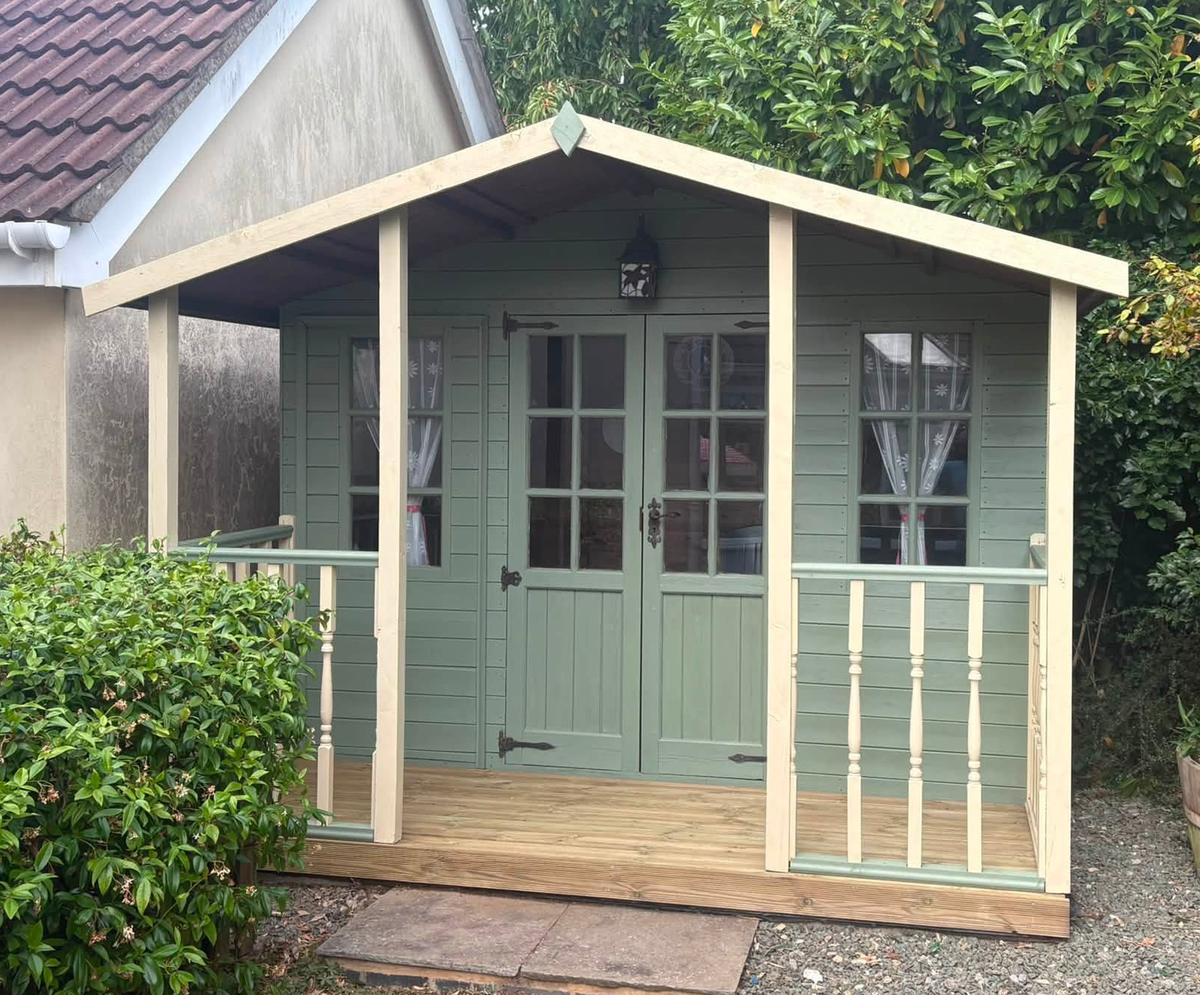 Summerhouse after: painted sage green with new roof, decking and balustrade